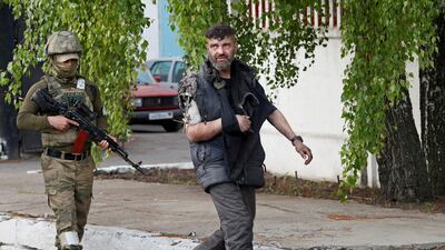 A wounded Ukrainian fighter surrenders after weeks holed up at Azovstal steel works in Mariupol. Reuters