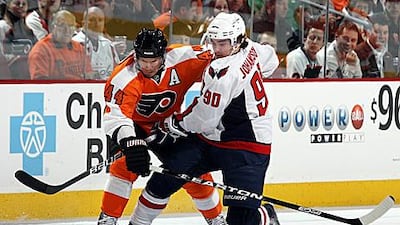Kimmo Timonen of the Philadelphia Flyers, left, pushes Marcus Johansson of the Washington Capitals off the puck during their clash at the Wells Fargo Center.