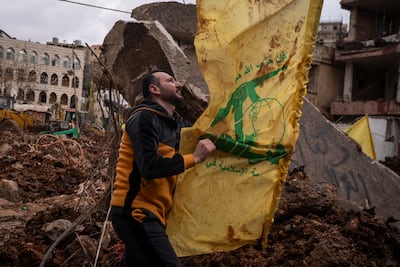 A resident raises a Hezbollah flag in the rubble of a destroyed building, in Nabi Chit. Getty Images
