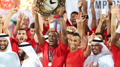 Ahmed Khalil lifts the league trophy with his Al Ahli teammates Ciel (99) after defeating Al Shaab during their final Arabian Gulf League match of the season at Rashid Stadium in Dubai. Christopher Pike / The National