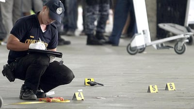 A police investigator works at the crime scene after a local town mayor was ambushed in a shooting attack at Manila's Ninoy Aquino International Airport . Che Cillo / Reuters