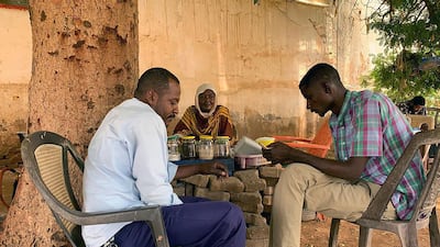 A Sudanese tea lady with two customers at her stall in the city of Omdurman. Hamza Hendawi for The National