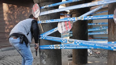 Leading Kurdish lawyer Tahir Elci's body lies on ground as a plain clothes police officer takes cover during a shoot out on November 28 in Diyarbakir. AFP Photo