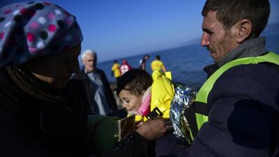 Migrants arrive with their child on the Greek island of Lesbos, after crossing the Aegean Sea from Turkey. Lesbos and other Greek Aegean islands are at the forefront of the greatest migration challenge facing the European Union since World War II. Bulent Kilic / AFP