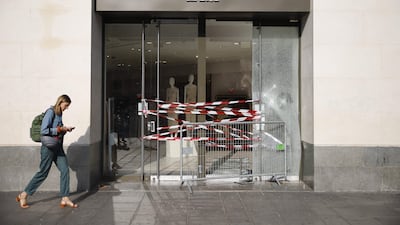 A pedestrian walks past the entrance to a damaged Zara store in Paris. AFP
