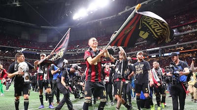 Atlanta United's Miguel Almiron waves a flag after defeating the Portland Timbers. Reuters