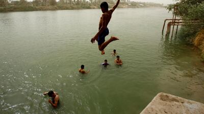 Children jump in to the Euphrates. Haider Hamdan / AFP