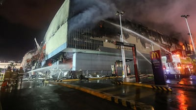 This photo taken on December 23, 2017 shows firefighters attempting to extinguish a fire at a shopping mall in Davao City on the southern Philippine island of Mindanao. Manman Dejeto / AFP