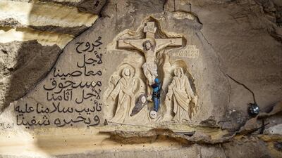 Polish artist Mario, sculptor of St. Simon the Tanner Monastery complex, works on a scene relief depicting the Crucifixion of Jesus Christ and a verse in Arabic from the Biblical Book of Isaiah reading "he was wounded for our transgressions, he was bruised for our iniquities, the chastisement of our peace was upon him; and with his stripes we are healed", at the church in the Egyptian capital Cairo's eastern hillside Mokattam district. Mario spent more than two decades carving the rugged insides of the seven cave churches and chapels of the rock-hewn St. Simon Monastery and church complex atop Cairo's Mokattam hills, with designs inspired by biblical stories. It was all done to fulfil the wishes of the church's parish priest who met Mario in the early 1990s in Cairo. The Polish artist, who had arrived in Egypt earlier on an educational mission, was then looking for an opportunity to serve God at the monastery. AFP
