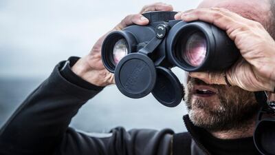 Abu Dhabi Ocean Racing skipper Ian Walker looks out at sea through binoculars during Leg 7 of the Volvo Ocean Race on Saturday. Matt Knighton / Abu Dhabi Ocean Racing / Volvo Ocean Race / May 23, 2015