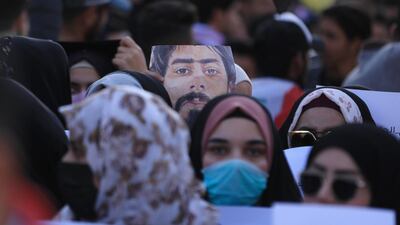 Iraqi demonstrators hold up a portrait of late fellow protester Safaa Al Saray, killed during the past three months of anti-government protests. AFP