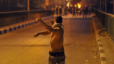 An Egyptian youth hurls stones at security forces during clashes in Cairo last night. The clashes followed a protest over the destruction of a church in the southern Egyptian province of Aswan.