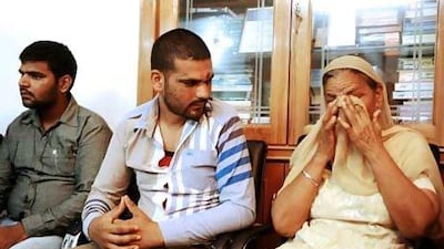 Recovering Indian drug addicts Amardeep Singh, centre, and his brother Harmandeep Singh, left, wait to see doctor JPS Bhatia at his clinic in Amristar.