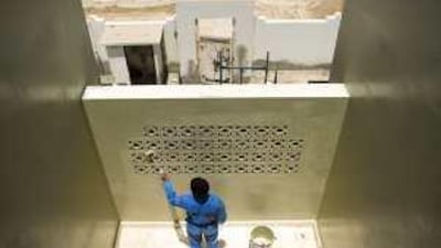 A worker paints a villa in Al Mirfa yesterday. Hundreds of villas are being renovated by the Western Region Municipality.