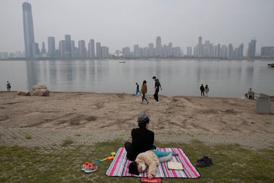 A child wearing a mask rests along the Yangtze River on April 5, 2020, in Wuhan in central China's Hubei province just days before the lifting of the city’s 76-day coronavirus lockdown. AP Photo
