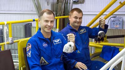Nick Hague of Nasa, left, and Alexey Ovchinin of Roscosmos hold up their mascots in Oct 6 2012 during final fit check activities prior to launch. Victor Zelentsov / Nasa