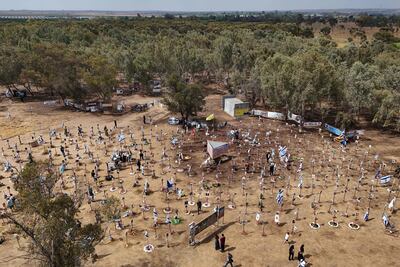 Visitors walk around portraits of people who were taken hostage or killed in the Hamas attack on the Supernova music festival on October 7, at the site of the festival near Kibbutz Reim in southern Israel on May 13. AFP