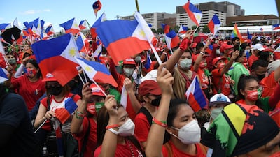 Supporters of presidential candidate Ferdinand Marcos Jr wave national flags in Paranaque City, suburban Manila. AFP