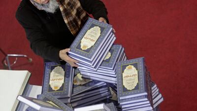 A man selects a series of religious books at the annual Cairo International Book Fair. AP