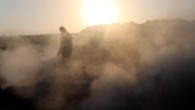 A Palestinian demonstrator is seen as smoke rises from a fire caused by objects dropped from Israeli drones during a protest against the US embassy move to Jerusalem and ahead of the 70th anniversary of Nakba, in Khan Younis in the southern Gaza Strip. Ibraheem Abu Mustafa / Reuters