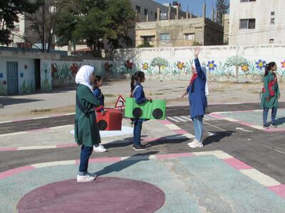 Seventh graders direct third-graders through a traffic simulation to teach road safety at the UNRWA-run Al Nuzha School for Girls in Amman, Jordan. Taylor Luck for The National