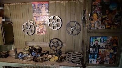 Movie posters, portraits of actors, and film reels are pictured in the projection room of the abandoned Aryob Cinema.