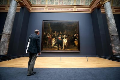 A visitor admires Rembrandt's masterpiece 'The Night Watch' in Amsterdam's Rijksmuseum. AFP