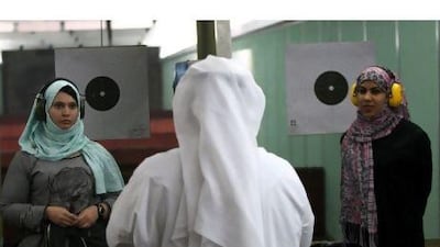 Raja Khalid, left, and Zainab Akhlaqi participate in a shooting competition organised by the Sharjah Golf and Shooting Club. Satish Kumar / The National