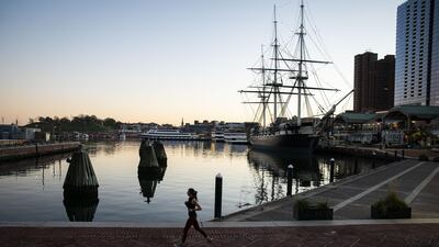 A runner passes through Inner Harbor in Baltimore, Maryland, US. Coronavirus infections continue to rise in the greater Washington region, with more than 5,000 new cases reported on Thursday, a daily record. Bloomberg