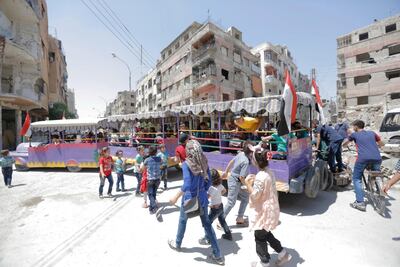 Adults and children ride a fun train amid destroyed houses in Douma, eastern Ghouta region, in Syria. EPA