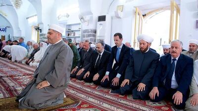 Syria's president Bashar Al Assad, third left, attending prayers on the first day of Eid Al Fitr, inside a mosque in Hama on June 25, 2017, Syria. Sana / Reuters