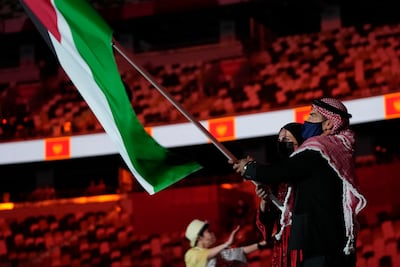 Julyana Al-Sadeq and Zeyad Eashash, of Jordan, carry their country's flag during the opening ceremony.