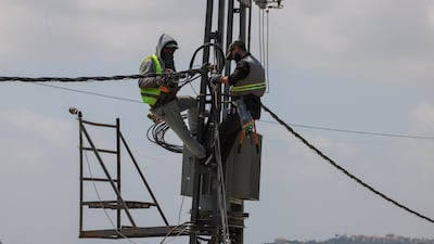Workers from the Lebanese electricity company repair cables in Tyre. Lebanon's power supply is unstable and many rely on generators. Reuters
