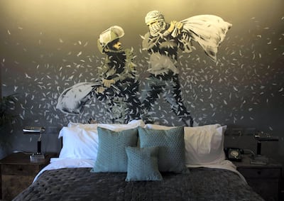 A wall painting by graffiti artist Banksy showing Israeli border policeman and Palestinian in a pillow fight in one of the rooms. Sipa Press