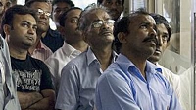 Men watch an Indian cricket league match outside a cafeteria on a side street in the Meena Bazar area of Bur Dubai.