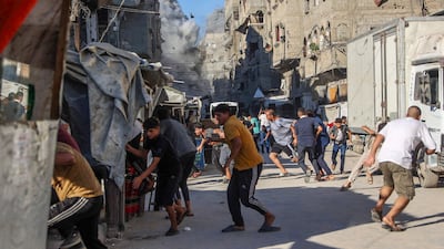 People run for cover after Israel launches strikes on Gaza City. AFP