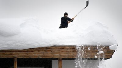 A Swiss police member removes fresh snow from the roof of the Kongress Hotel next to the Congress Centre on the eve of the 48th Annual Meeting of the World Economic Forum, WEF, in Davos. Laurent Gillieron
