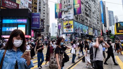 Pedestrians wear face masks as a precautionary measure against the Covid-19 coronavirus as they walk across a road in Hong Kong on May 13, 2020. AFP