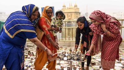 Sikh devotees light candles to pay respect on the occasion of Bandi Chhor Divas, a Sikh festival coinciding with Diwali, the Hindu festival of light, at the Golden Temple in Amritsar on November 14, 2020. / AFP / NARINDER NANU