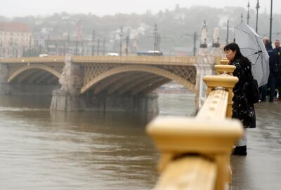A woman standing and looks at Margit Bridge in Budapest. AP