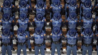 New Washington State Patrol troopers bow their heads during a prayer at the Patrol’s graduation ceremonies in the Capitol rotunda in Olympia, Washington. The 49 graduates of the 107th Trooper Basic Training Class went through nearly six months of field and academy training, and were given the oath of office by Washington State Supreme Court Justice Mary Fairhurst. Elaine Thompson / AP Photo