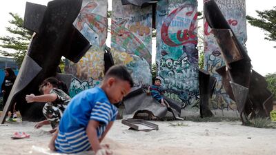Indonesian children play near pieces of Berlin Wall erected as parts of an installation art by Indonesian artist Teguh Ostenrik, at Kalijodo Park in Jakarta, Indonesia. AP Photo