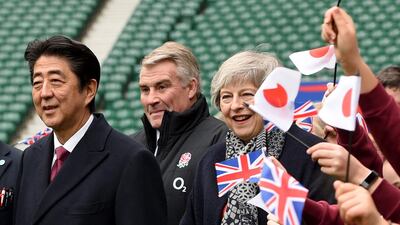 epa07273065 British Prime Minister Theresa May (R) and Prime Minister Shinzo Abe of Japan (L) react as they meet children in Twickenham stadium in London, Britain, 10 January 2019. The Prime Ministers met kids from a 'CBRE all schools programme' which is a RUF initiative to help children from states schools to play more rugby. EPA/FACUNDO ARRIZABALAGA