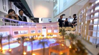 Visitors look at an Eshraq model on display yesterday Cityscape in Abu Dhabi.