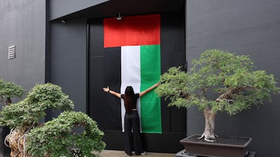 A flag on the door of Bocasu Specialty Coffee in Al Quoz, Dubai. Flags have been hung across the Emirates to display national pride. Chris Whiteoak / The National