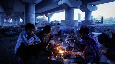 A migrant family sit around a fire warming themselves and preparing breakfast under a flyover in Mumbai. Danish Siddiqui / Reuters