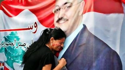 A woman mourns at a poster with an image of senior intelligence official Wissam Al Hassan during a protest against his killing, at Martyrs' square in downtown Beirut on Saturday.