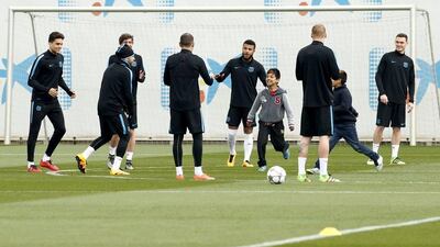 Barcelona’s players play football with boys who invaded the pitch during a training session. REUTERS/Albert Gea