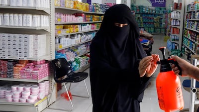 A worker disinfects the hands of a woman before she enters a supermarket in Sanaa, Yemen. EPA