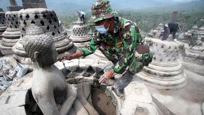 An Indonesian soldier removes volcanic ash from a Buddha statue at Borobudur temple in Magelang, Central Java, Indonesia, on February 17, 2014. Mount Kelud in East Java province erupted February 13, killing four people and spewing ash and rock that covered much of the island. More than 56,000 people were displaced. Bimo Satrio / EPA